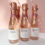 Mini champagne or prosecco labels for bridesmaid proposal box. Simple calligraphy writing with a coloured heart, personalised with names and roles. 